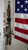 Customer image of a war belt hanging from Hugo Industries cobra belt hanger next to an american flag.
