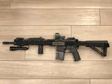 Black TOIM customizable quick adjust two point sling attached to a rifle in a tucked and storage ready configuration using the elastic keeper